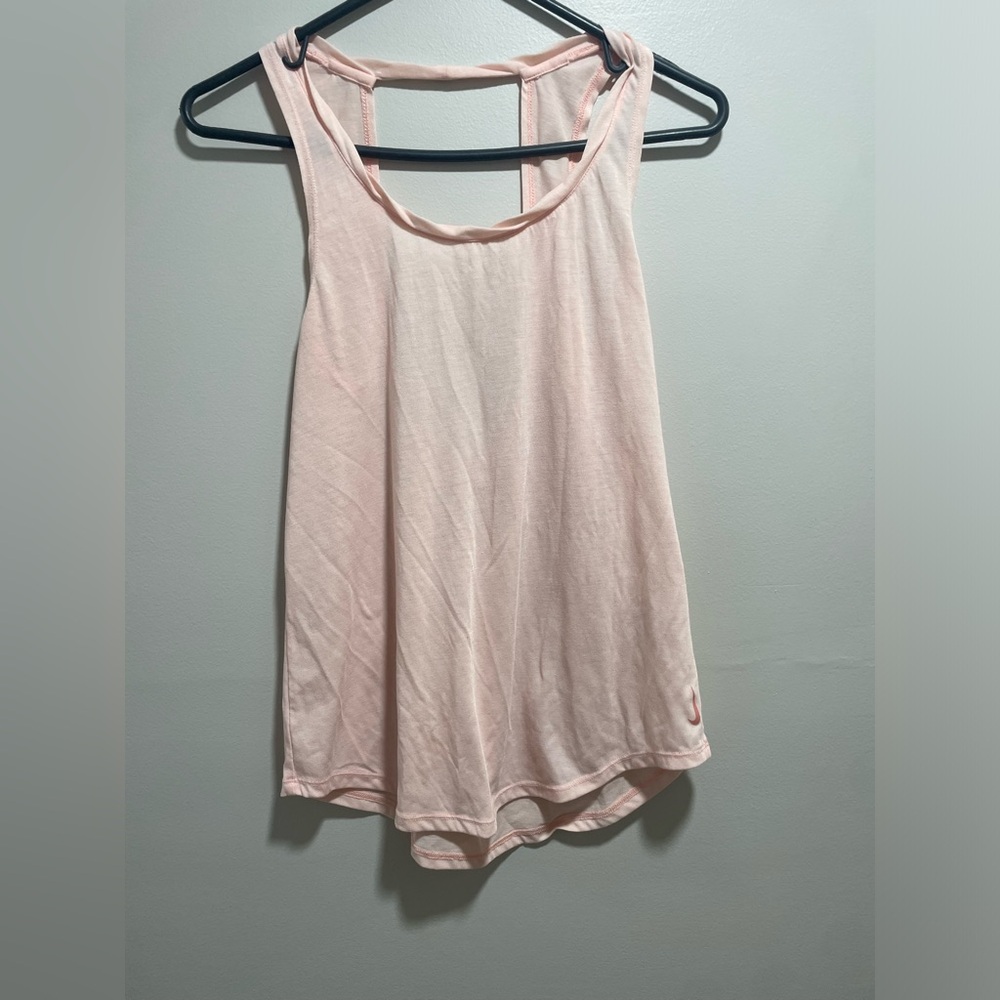 Nike light pink athletic tank top with open back detail.